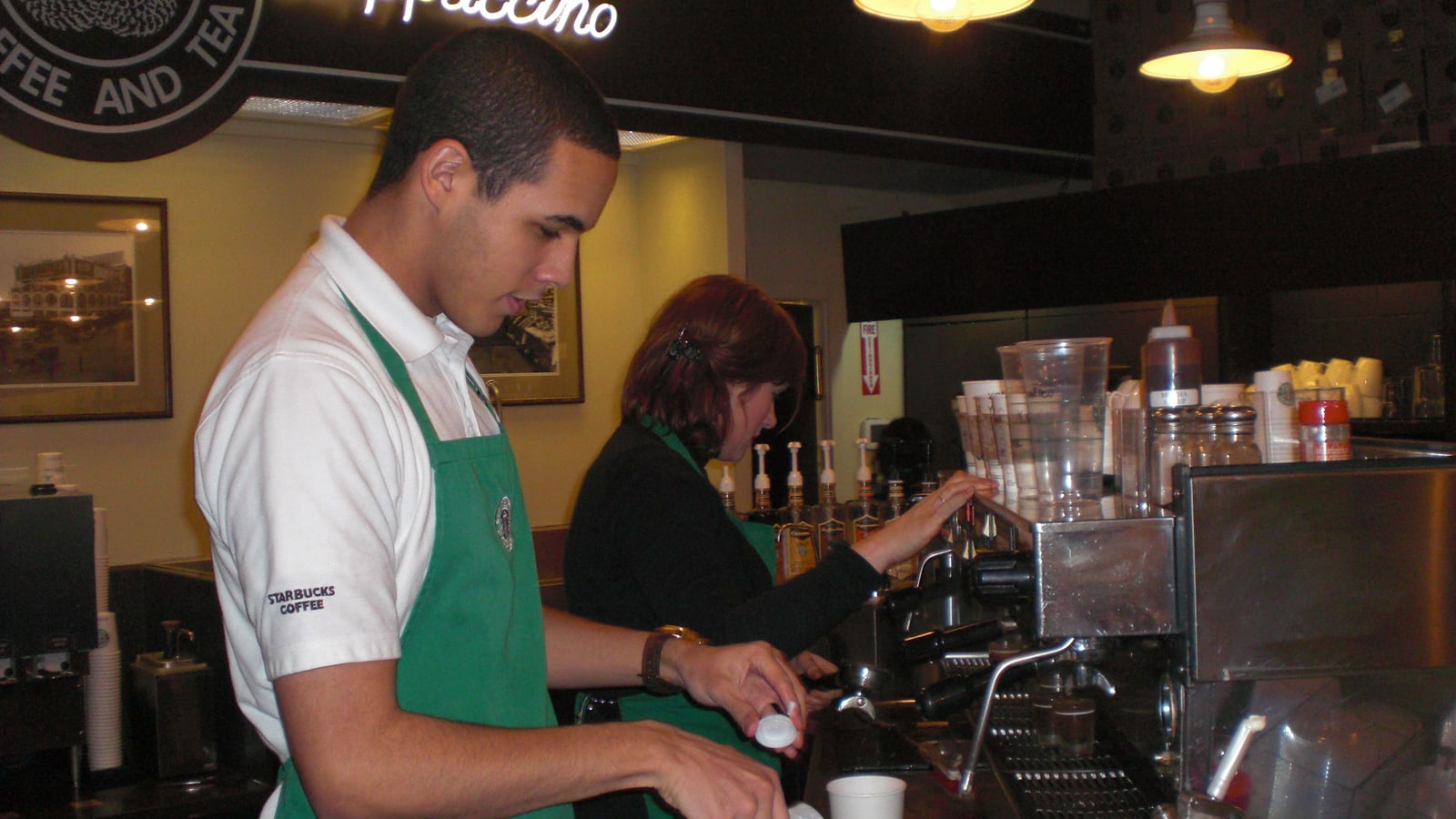 Baristas working behind the counter at the original Starbucks store.