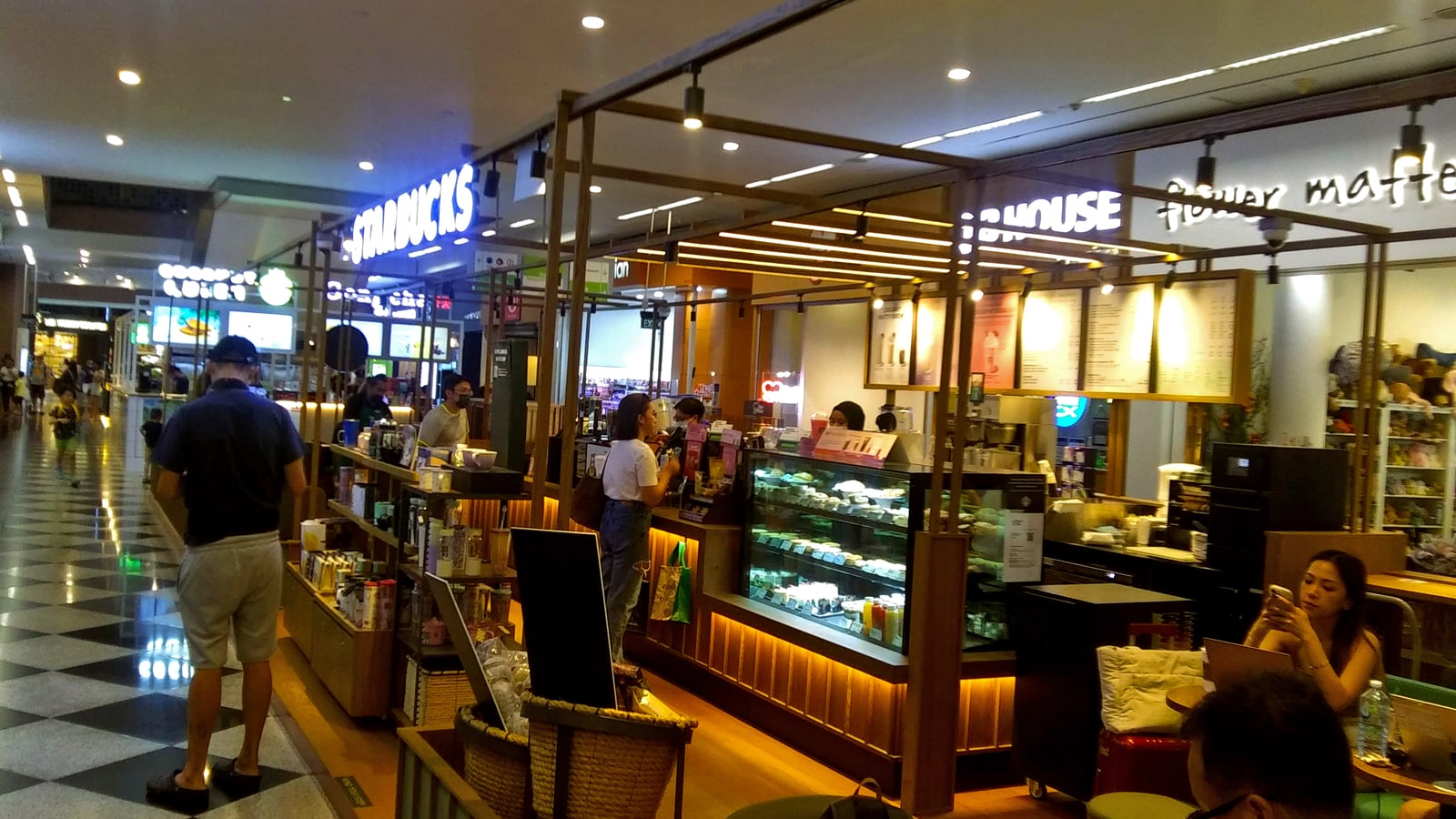Starbucks coffeehouse operating inside Millenia Walk in Singapore with counter, seating, customers, and retail activity visible.