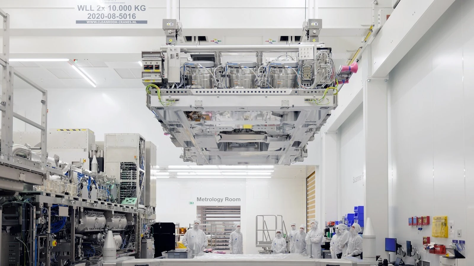 An ASML High-NA top module being lifted during assembly in a Veldhoven cleanroom.