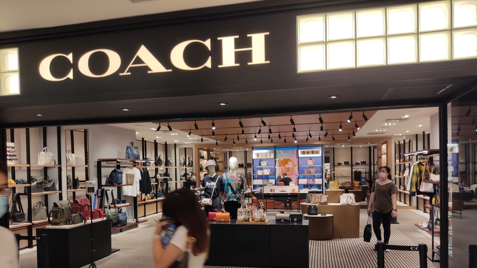 Coach store in a shopping mall with bags and retail merchandising visible.