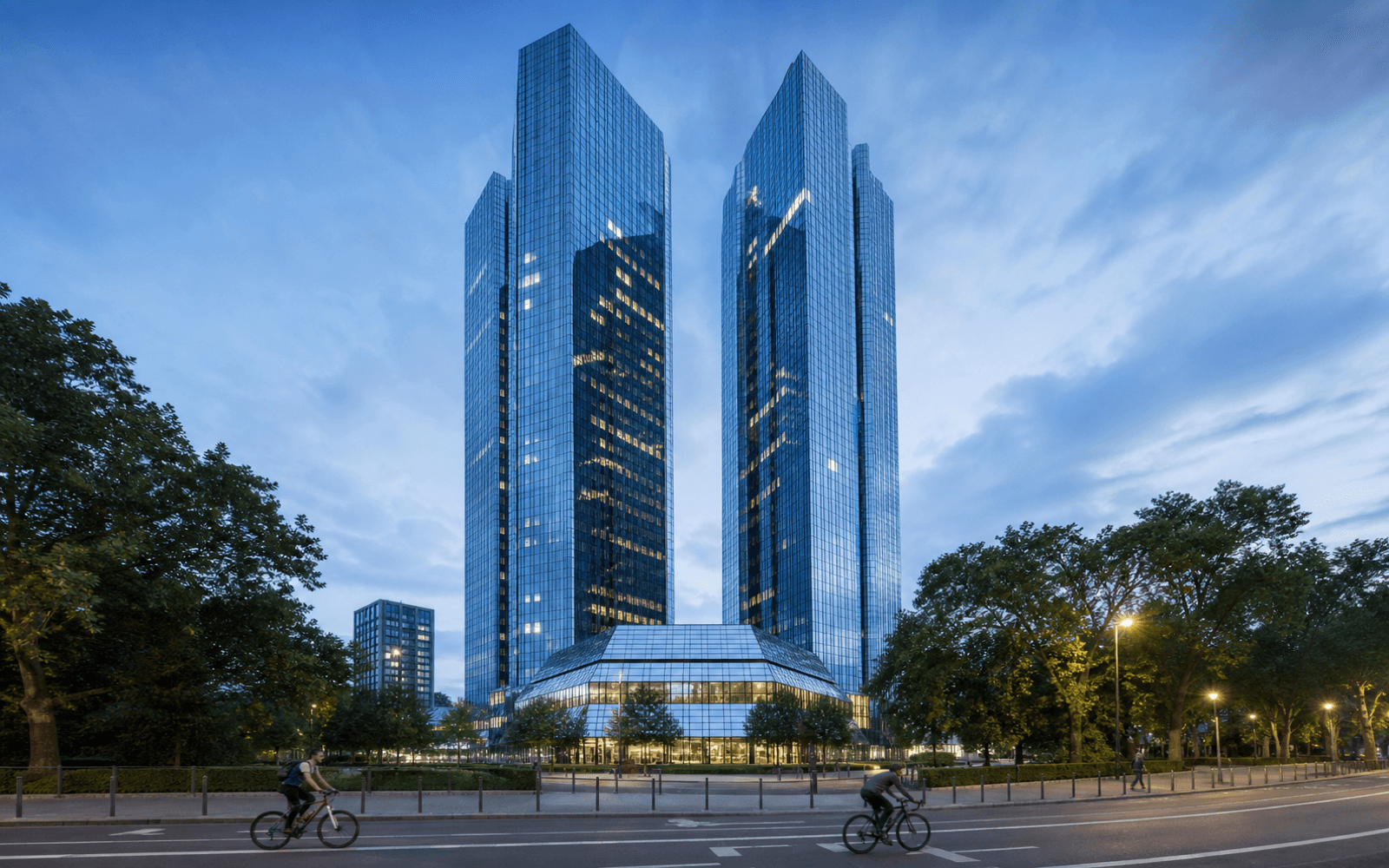 Blue-glass banking towers in Frankfurt at dusk, expressing Deutsche Bank's institutional scale.