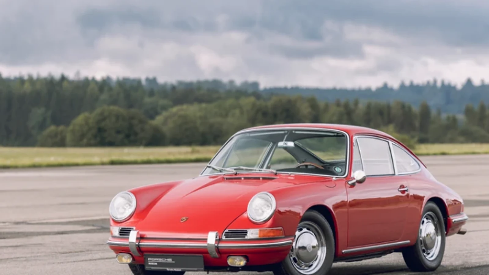 Classic red Porsche 911 on track-side tarmac.
