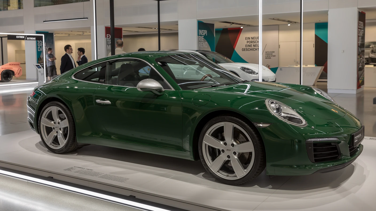 Green Porsche 911 shown in a museum setting.