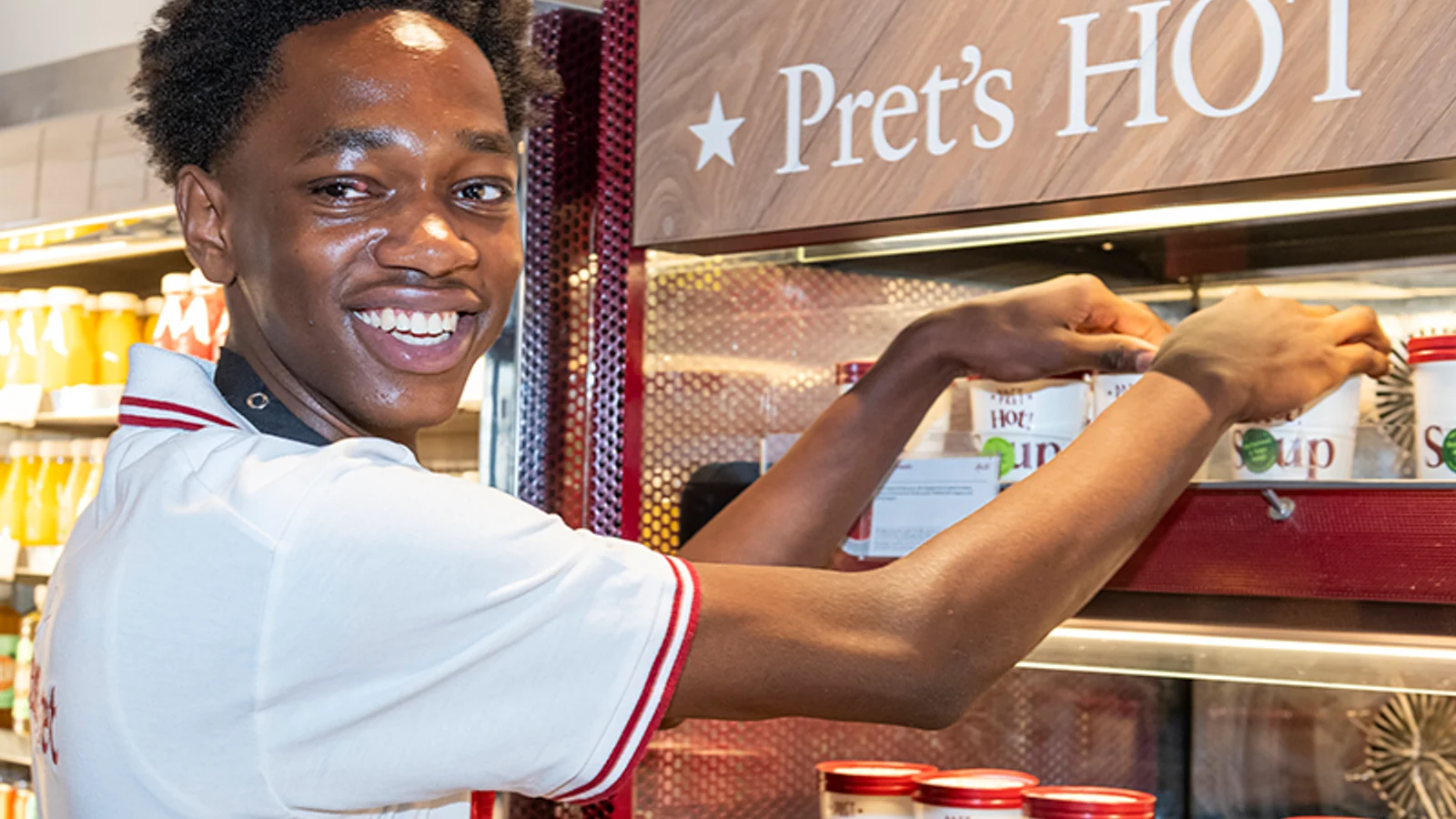 Pret team member working with hot food in a shop kitchen.