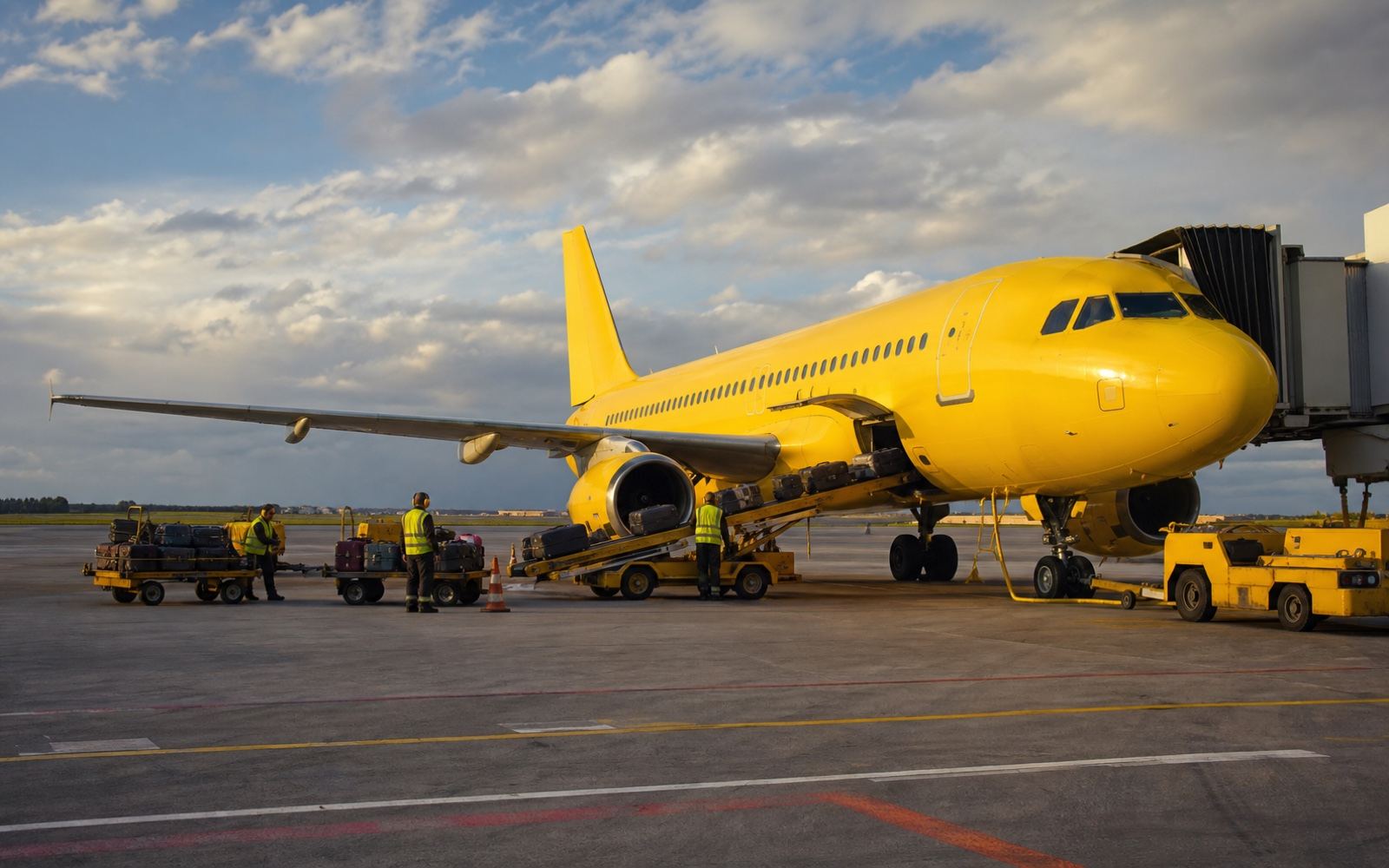 A logo-free bright yellow low-cost aircraft on an airport ramp during the airline's final operating era.