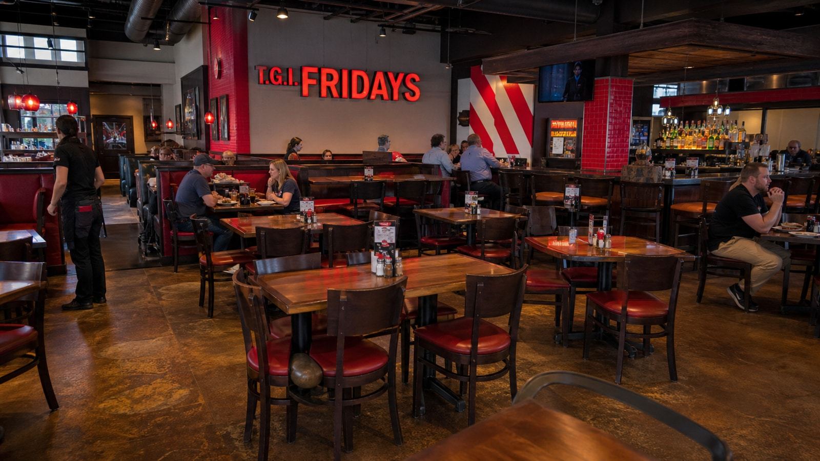 Active TGI Fridays dining room during a soft midweek service with many open tables.