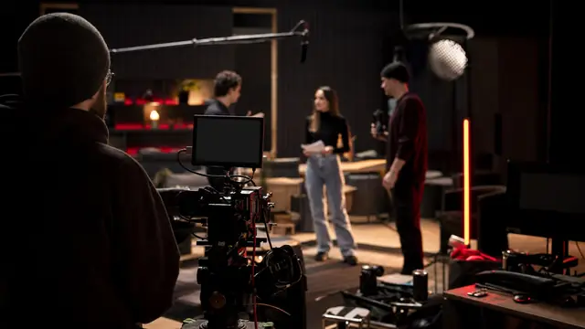 Netflix production set with camera, crew, and red-black studio lighting.
