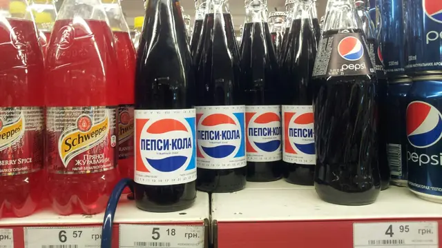 Classic Pepsi bottles in a supermarket cooler row showing blue-red package recognition.