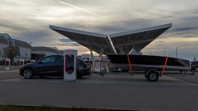 Tesla vehicle at a Supercharger showing the charging network as part of the ownership promise.